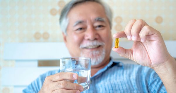 Älterer Mann nimmt Omega-3-Kapsel.