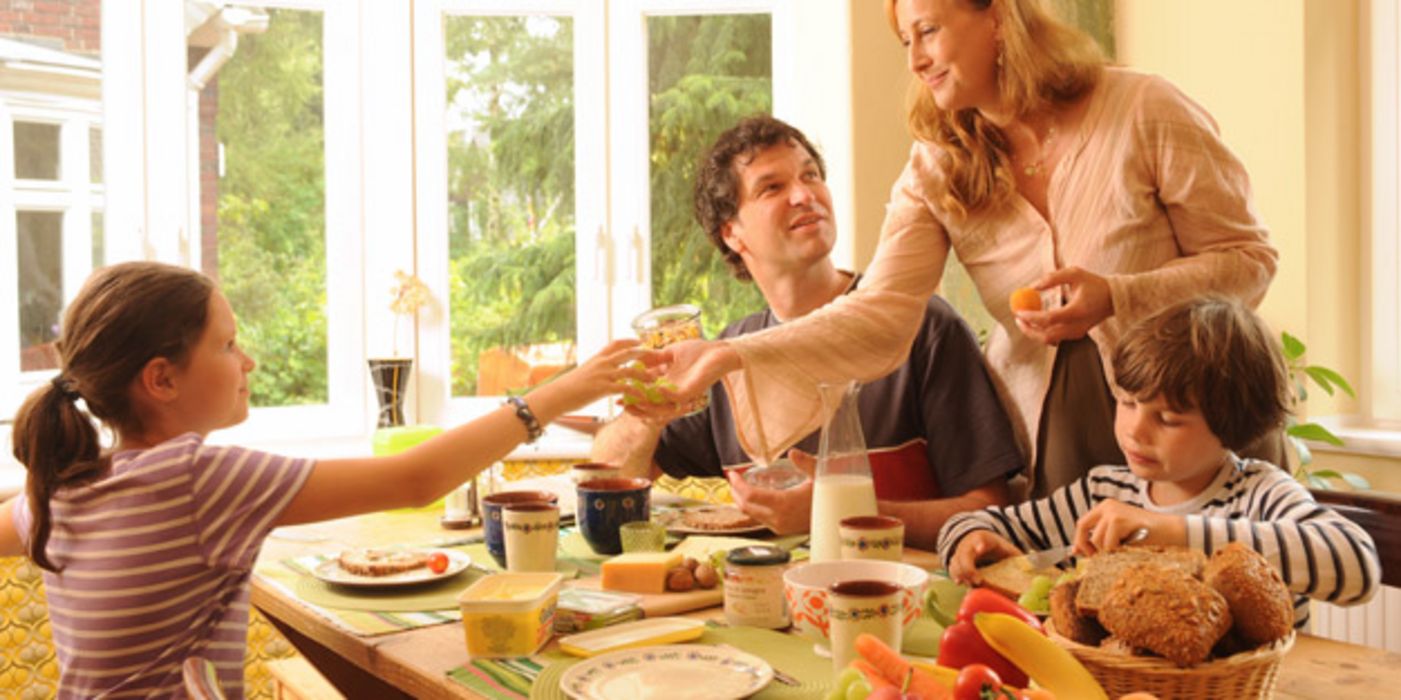 Familie: Vater, Mutter in den 30ern, Mädchen, ca. 10 Jahre, Junge ca. 7 Jahre, beim üppigen Frühstück