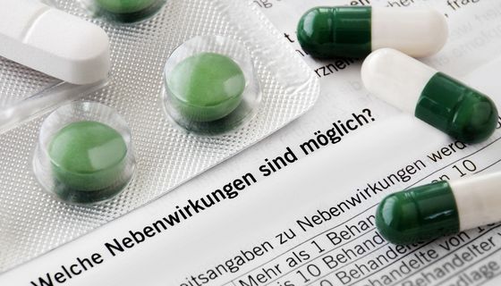 Grüne Tabletten auf Beipackzettel