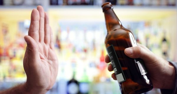 Mann, lehnt eine Flasche Bier ab.