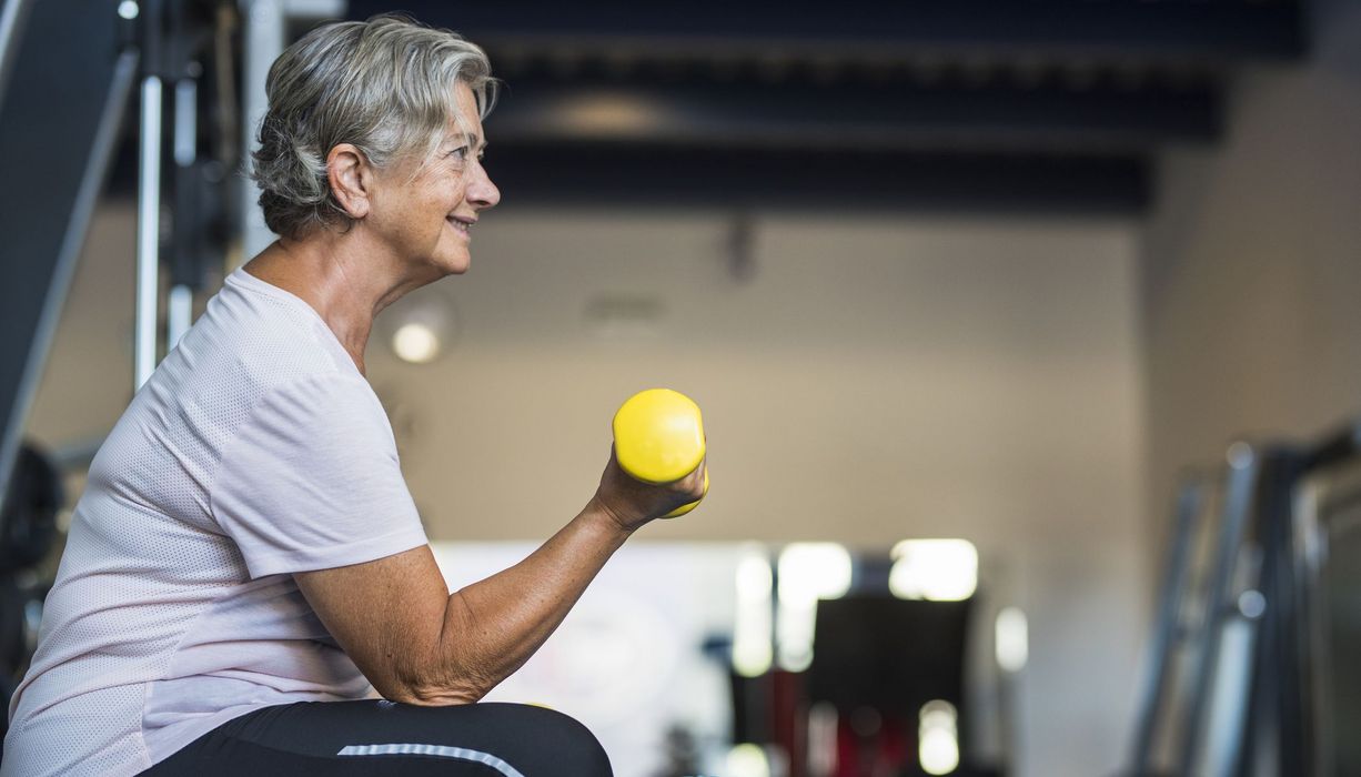 Ältere Frau, macht Krafttraining im Fitnessstudio.