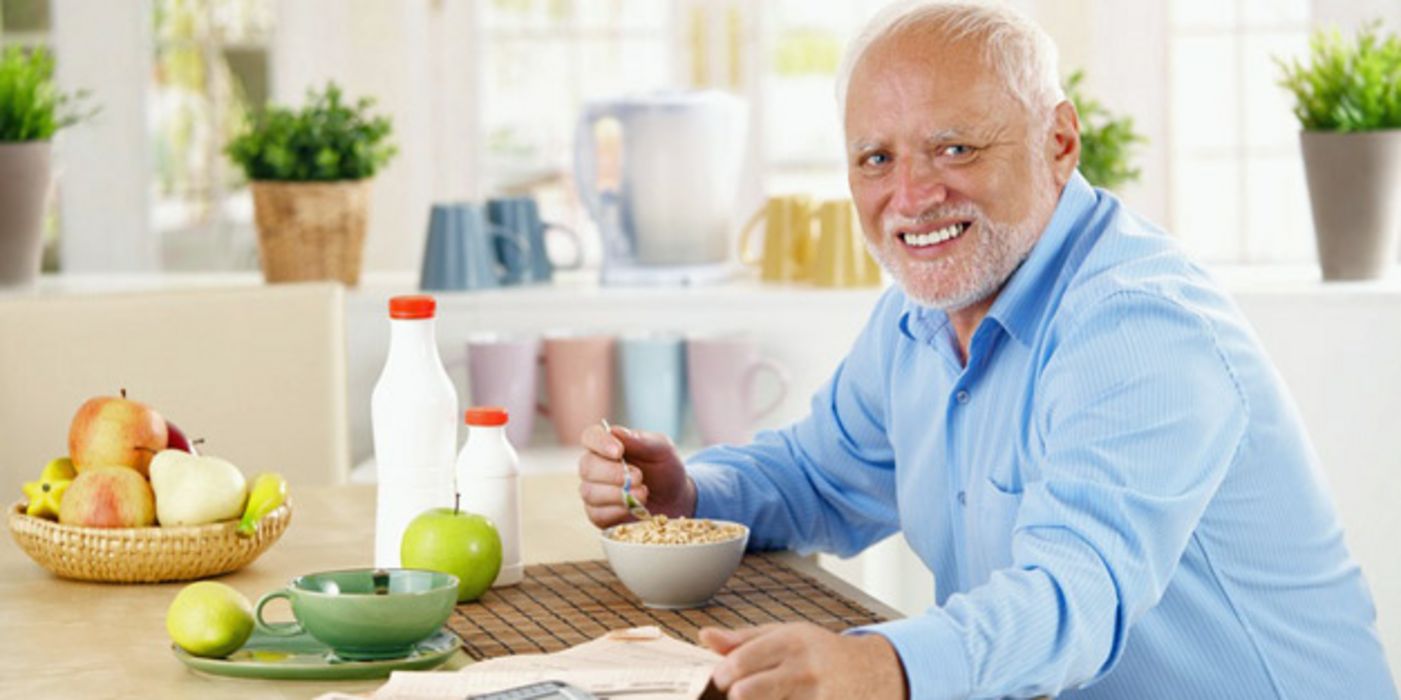 Mann sitzt an einem Esstisch und frühstückt gesund