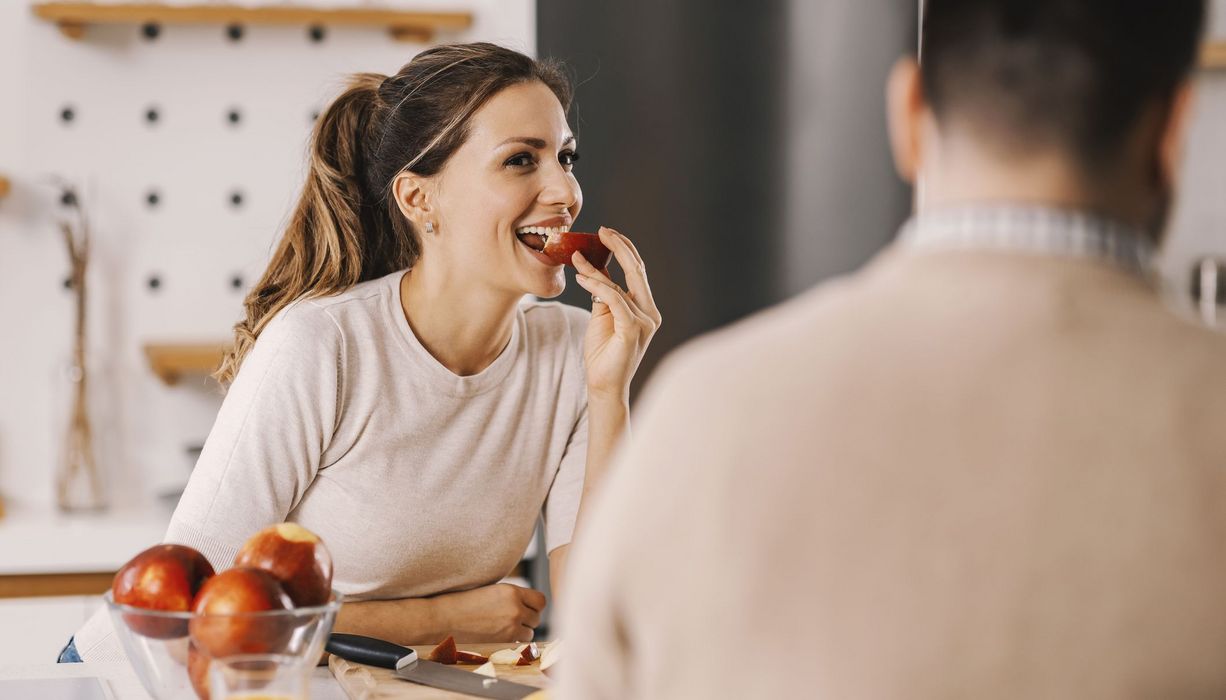 Junge Frau, beißt in einen Apfel.