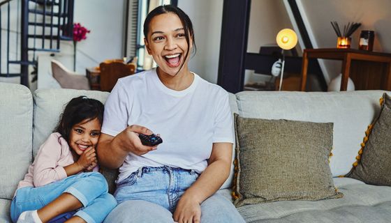 Mutter und Tochter schauen gemeinsam TV.