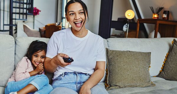 Mutter und Tochter schauen gemeinsam TV.