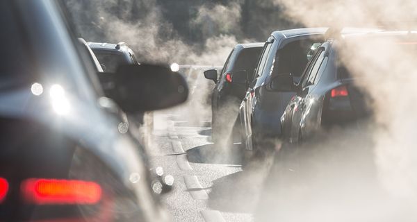 Autos mit Abgasen auf einer Straße.