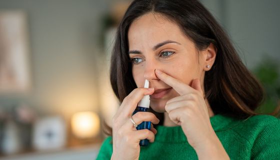 Frau wendet Nasenspray an.