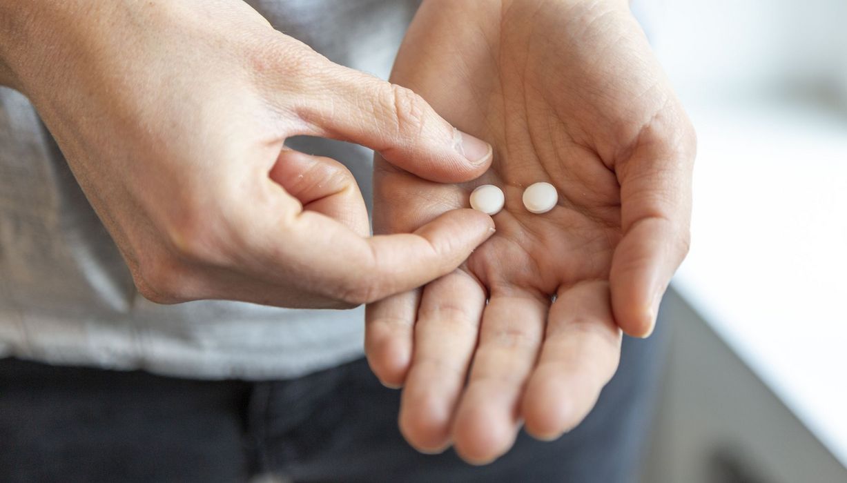 Zwei Tabletten in einer Hand.