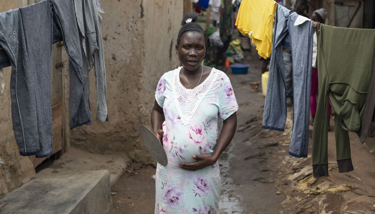 Schwangere dunkelhäutige Frau in einem Slum.