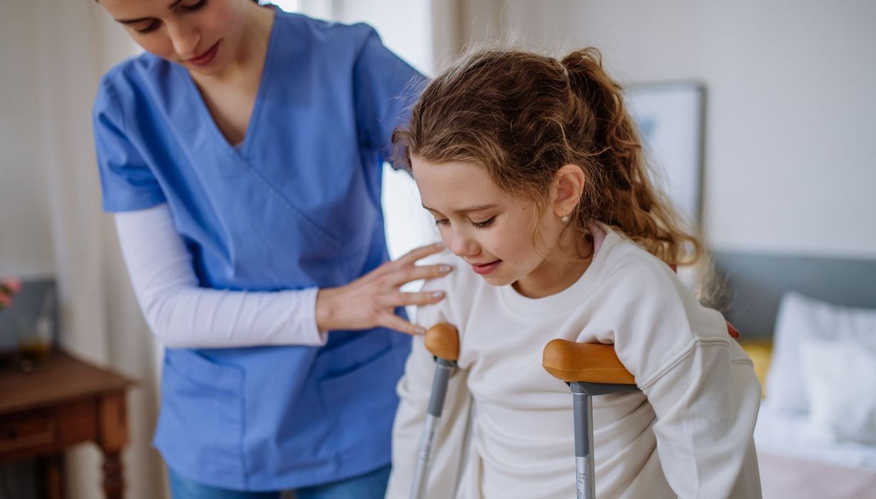 Kind, auf Krücken im Krankenhaus.