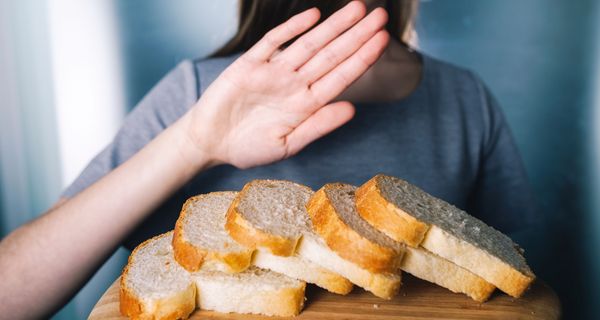 Frau, lehnt einen Teller mit Brot ab.