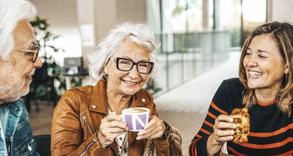 Älteres Paar trinkt Kaffee mit ihrer Tochter.