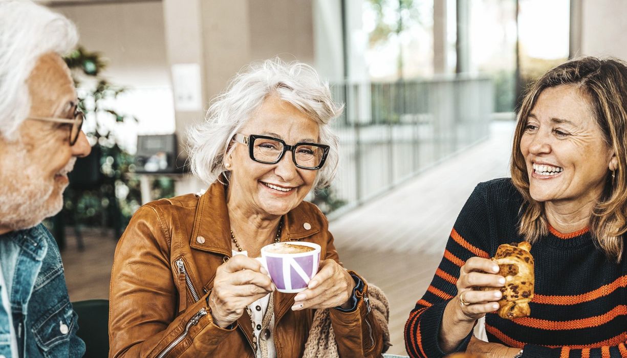 Älteres Paar trinkt Kaffee mit ihrer Tochter.