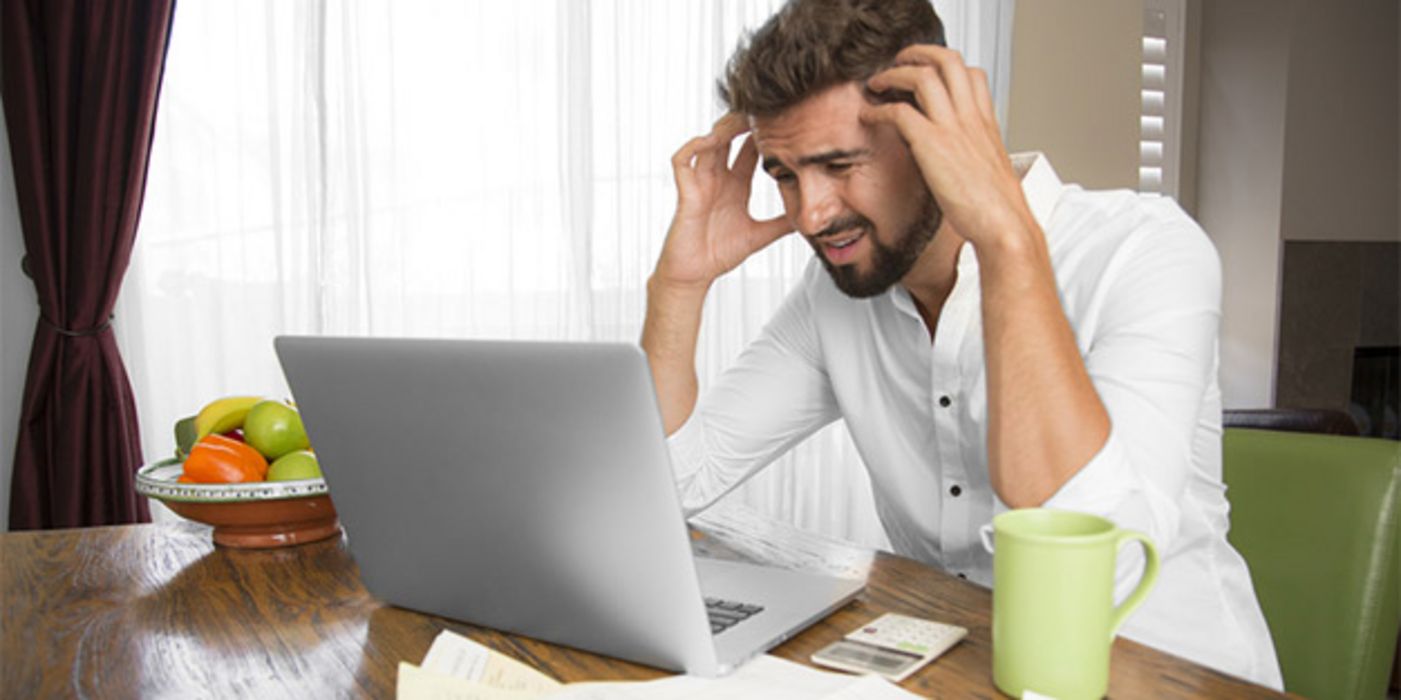 Junger gestresster Mann vor dem Computer.