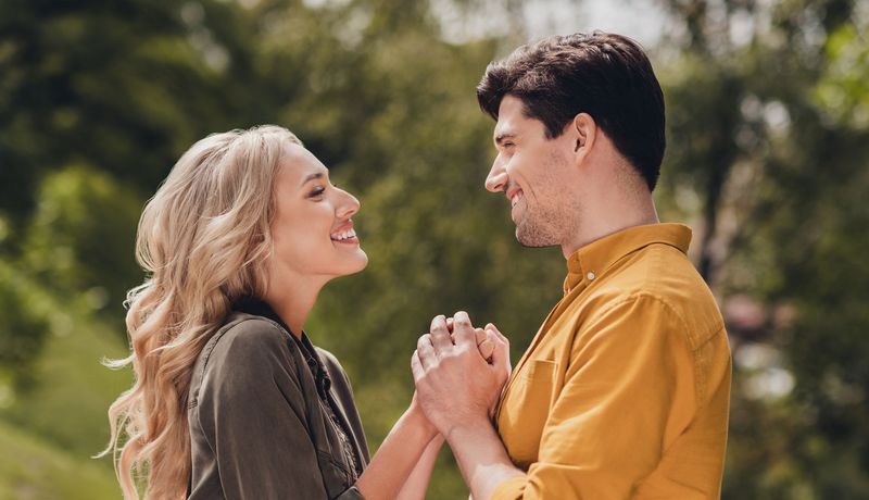 Ein Paar hält sich an den Händen und strahlt sich an.