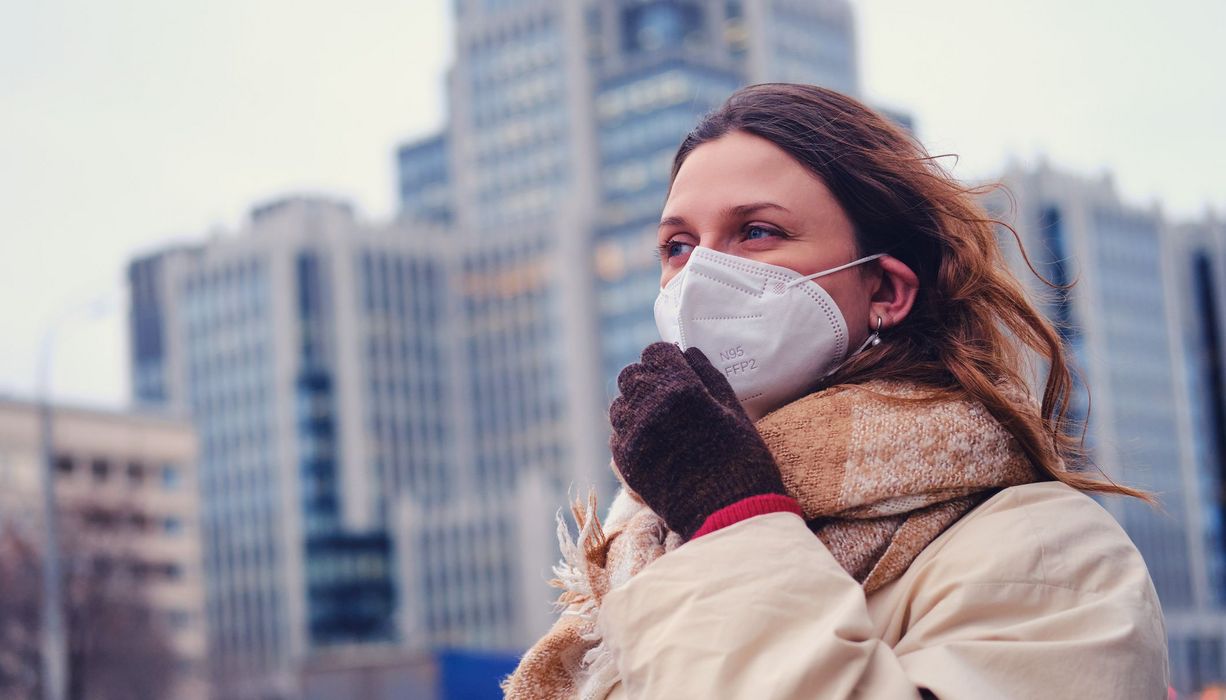 Frau mit Maske, im Winter in der Stadt.