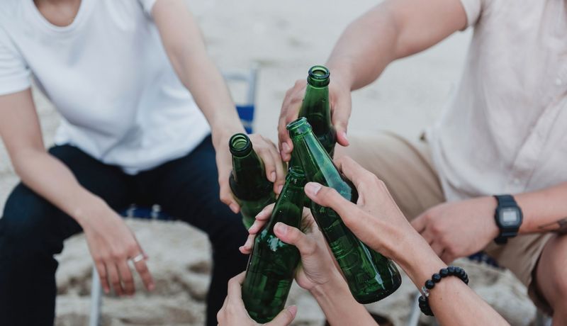 Jugendliche, stoßen mit Bier an.