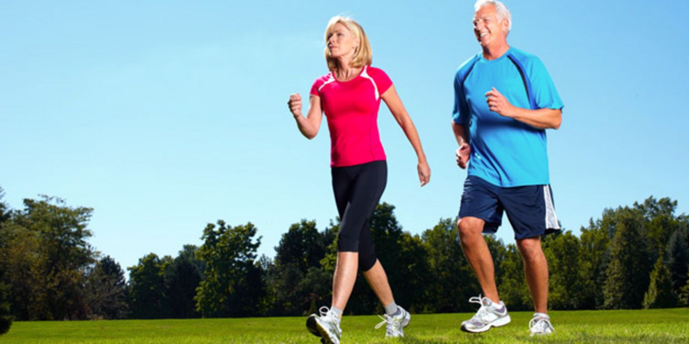 Seniorin und Senior im Park beim Walken/Joggen