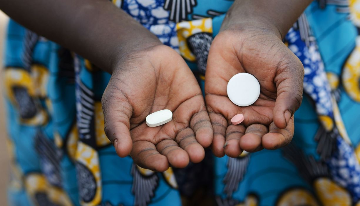 Junges Mädchen, hält drei Tabletten in ihren Händen.