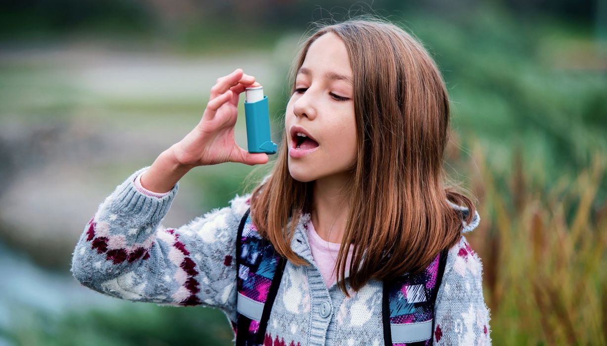 Mädchen, benutzt einen Asthma-Inhalator.