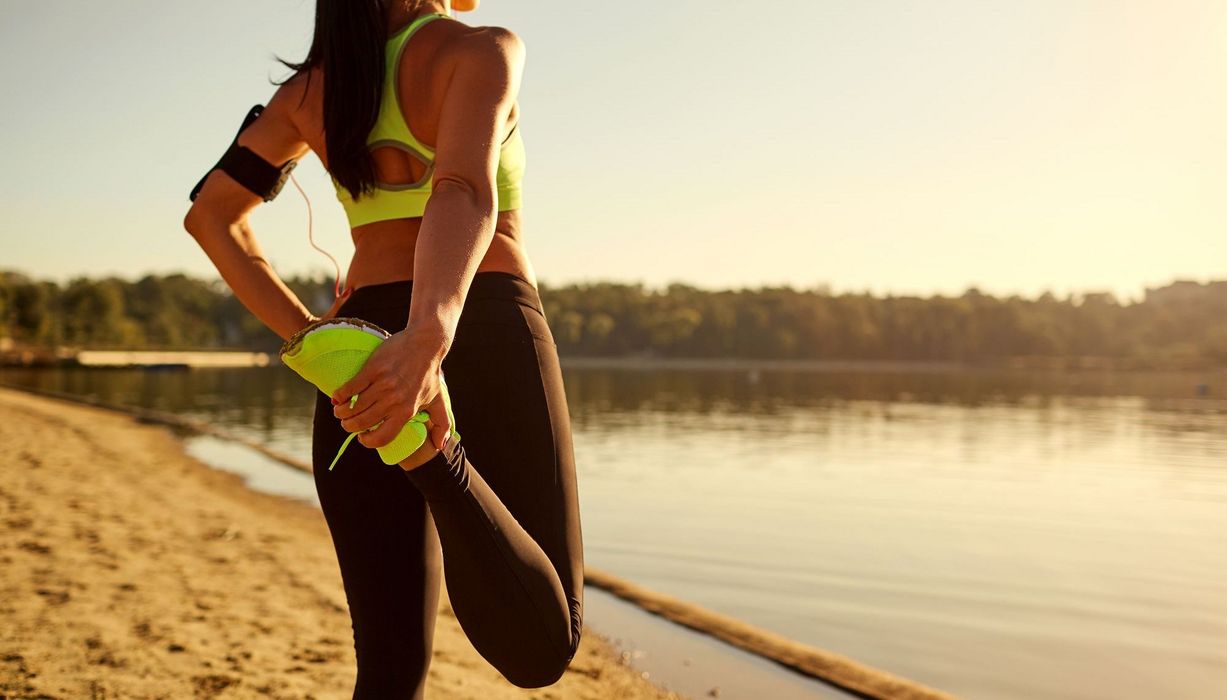 Frau, dehnt sich beim Sport.