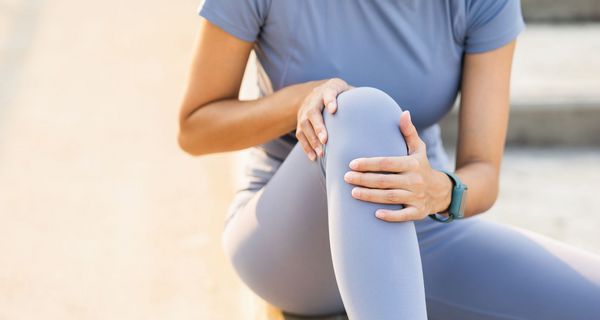 Frau, hält sich ihr Knie.