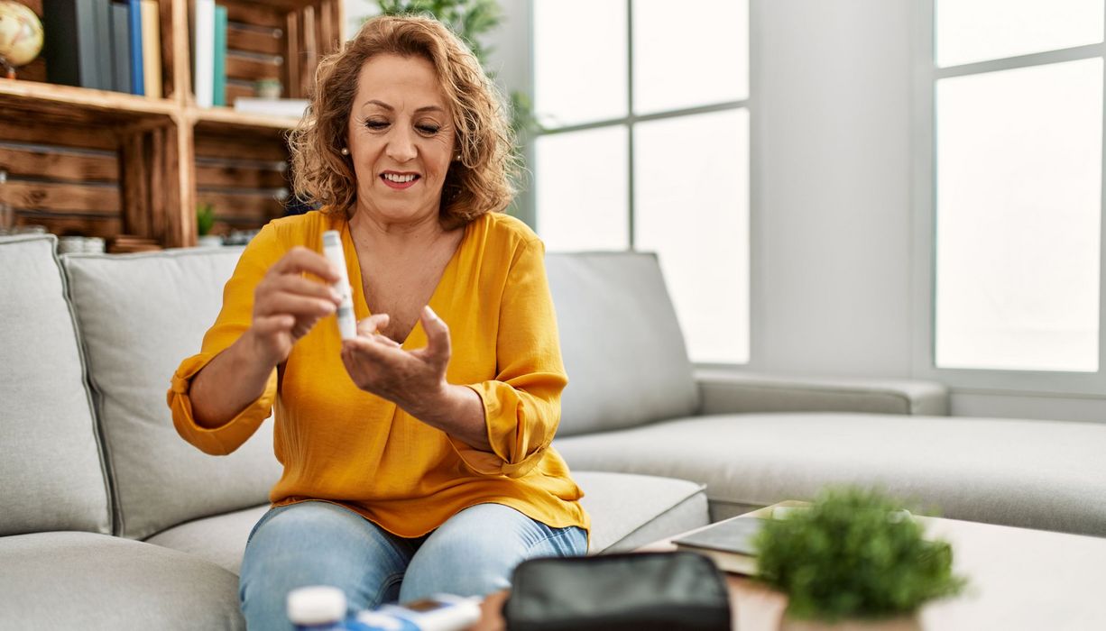 Ältere Frau, misst sich ihren Blutzucker zur optimalen Diabetes-Therapie.