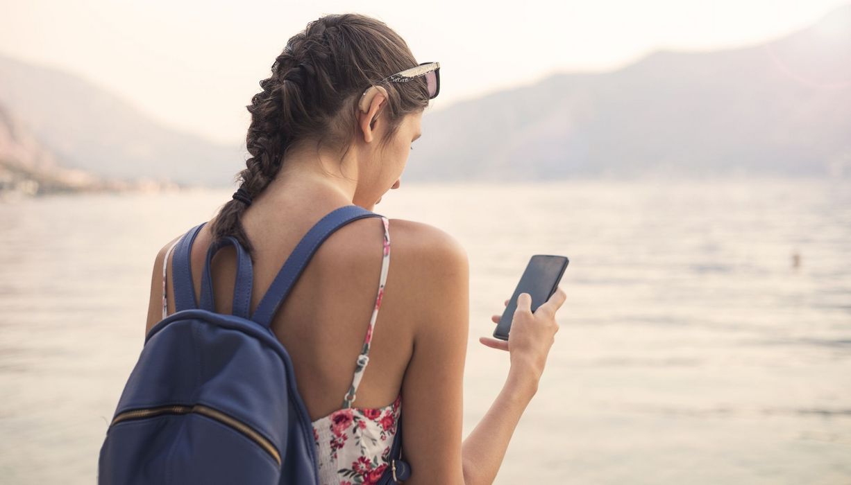 Junge Frau, mit Hörgerät am Strand.