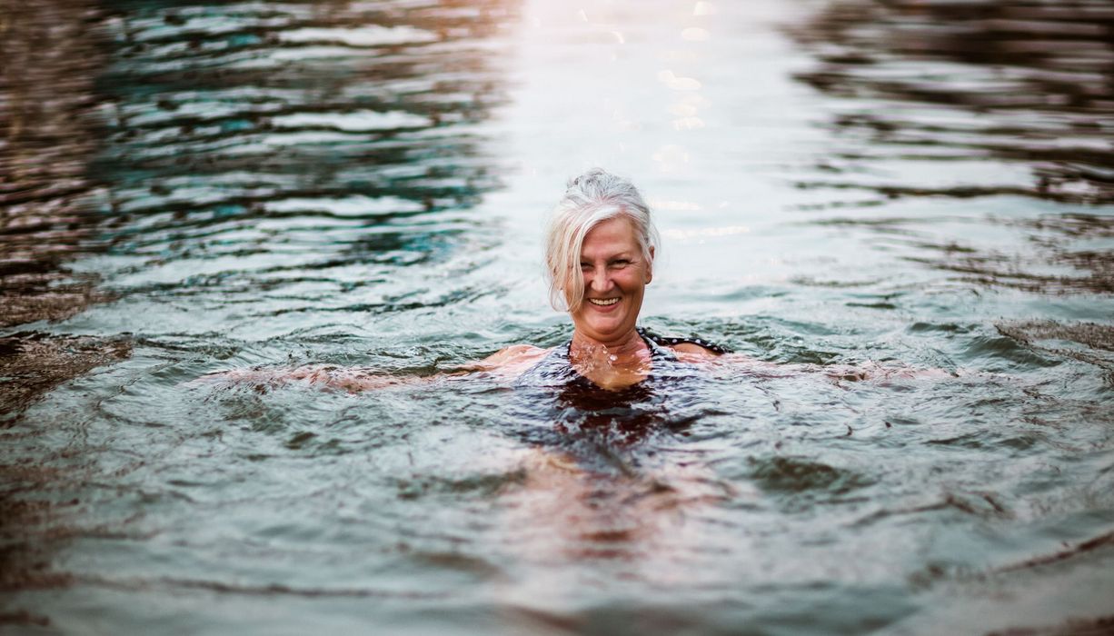 Ältere Frau, schwimmt in kaltem Wasser.