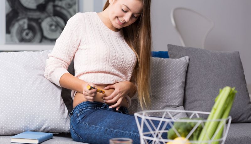 Junge Frau spritzt sich Insulin.