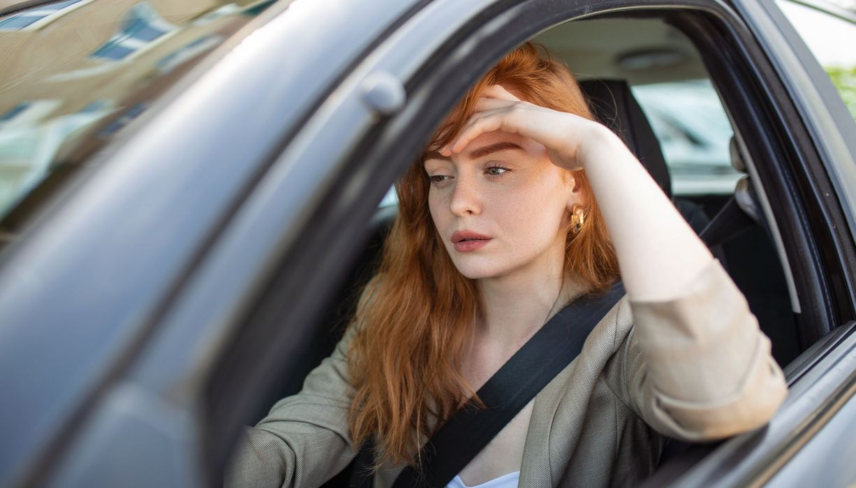 Junge Frau, sitzt im Auto.