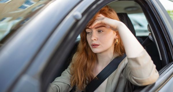 Junge Frau, sitzt im Auto.