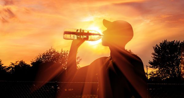 Mann, an einem heißen Sommertag, trinkt Wasser.