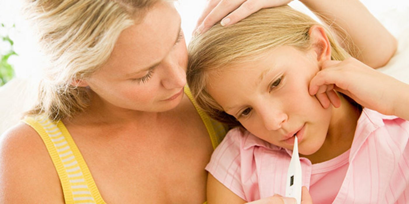 Mutter misst bei Schulkind (Mädchen, ca. 9 Jahre) Fieber und stützt mit einer Hand ihren Kopf. Beide sind blond.