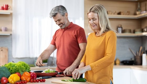Paar 40+ bereitet ein gesundes Essen zu.