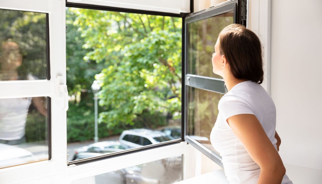 Frau, öffnet ein Fenster.