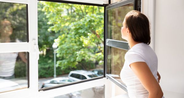 Frau, öffnet ein Fenster.