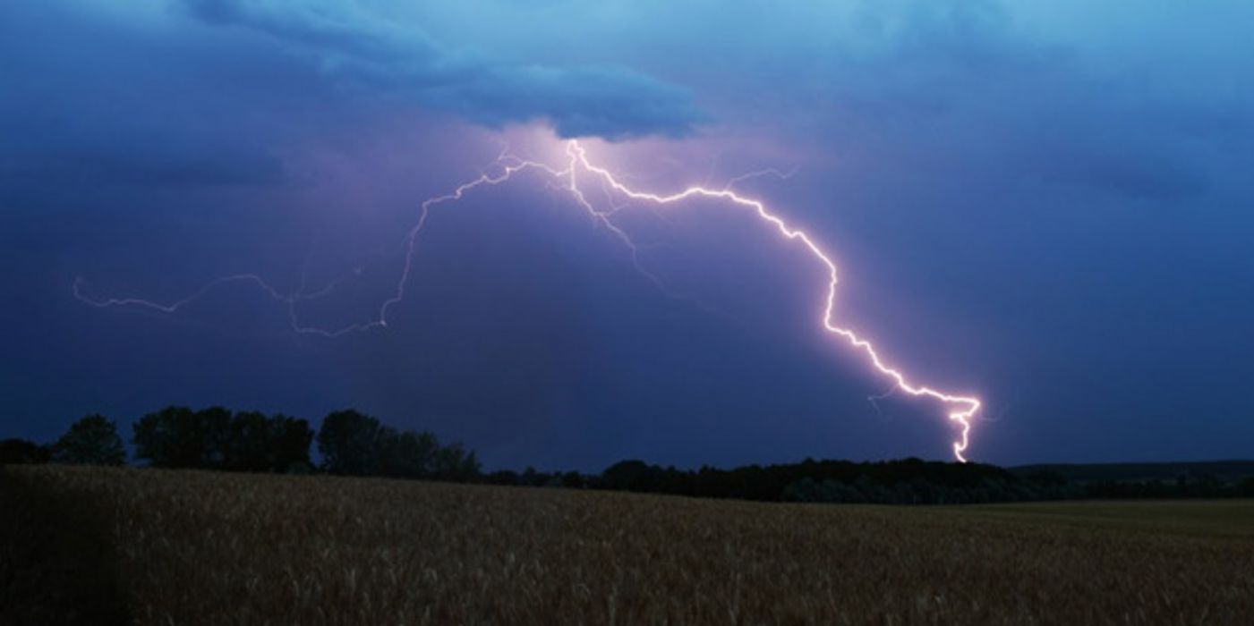 Gewitterlandschaft mit Getreidefeld im Vordergrund