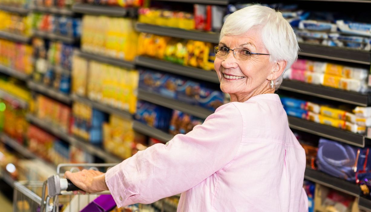 Seniorin, kauft im Supermarkt ein.