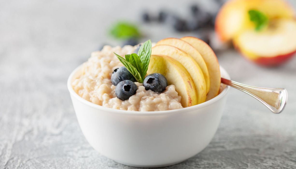 Schale mit Porridge aus Haferflocken und Obst.