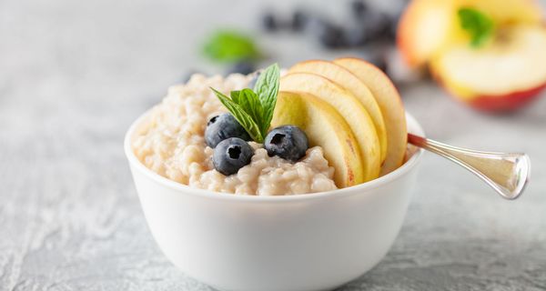 Schale mit Porridge aus Haferflocken und Obst.