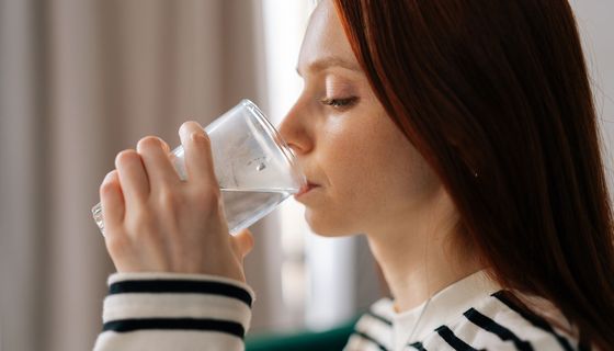 Frau, trinkt ein Glas Wasser.