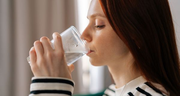 Frau, trinkt ein Glas Wasser.