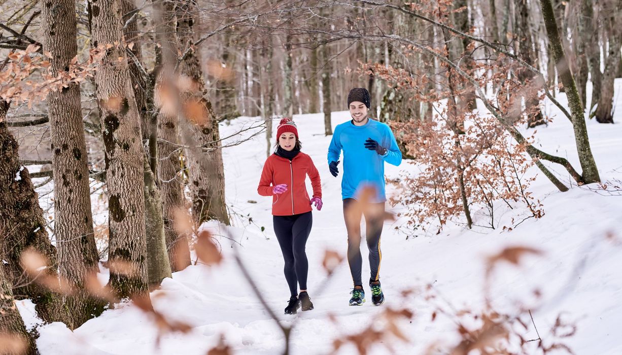 Mann und Frau, joggen bei Schnee.