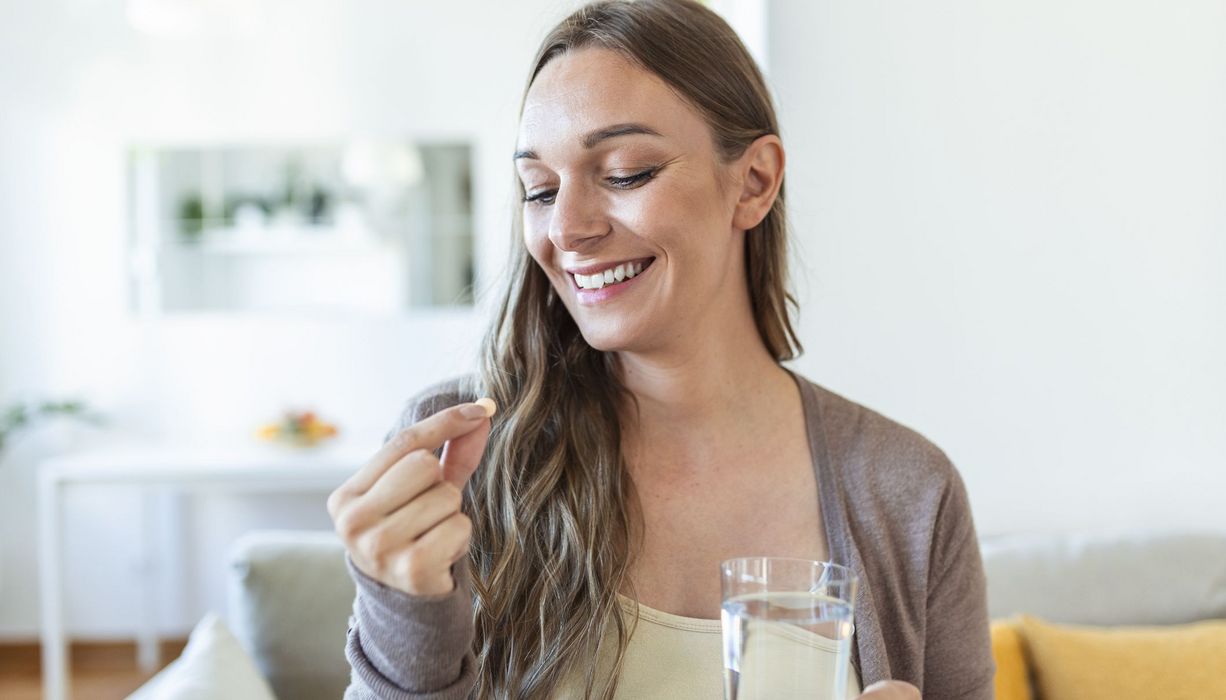 Junge Frau, nimmt eine Vitamintablette.