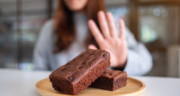 Frau, lehnt zwei Brownie-Stückchen ab.