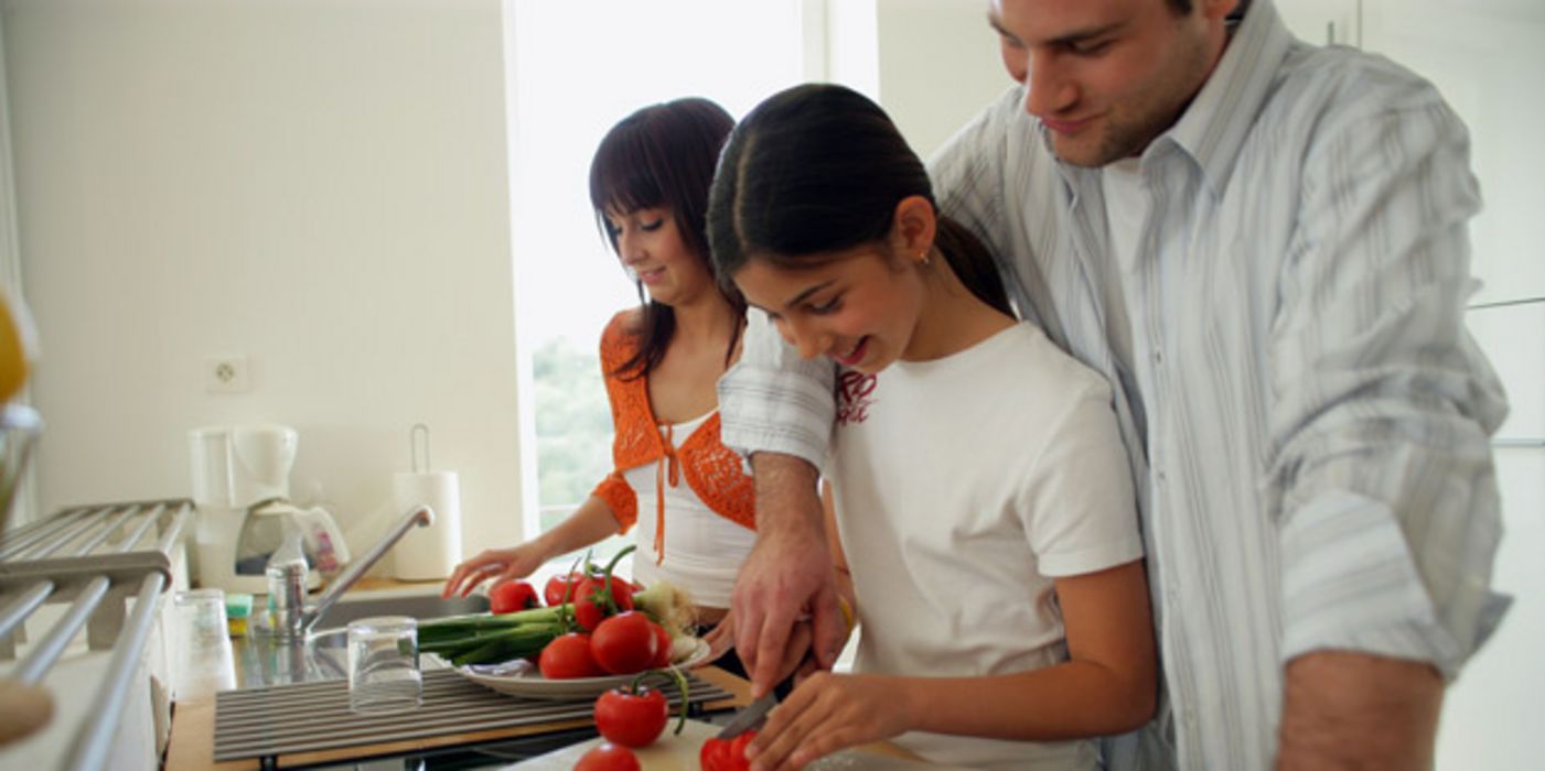 Junge Familie kocht mit Tomaten