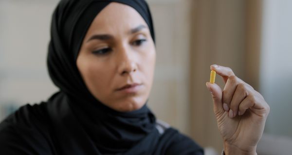 Muslimische Frau, betrachtet ein Medikament.