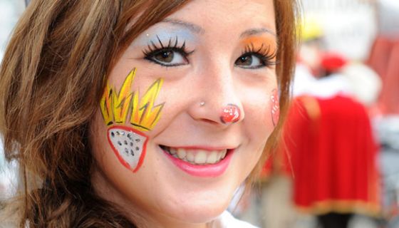 Junge Karnevalistin mit Kölner Stadtwappen auf der Wange