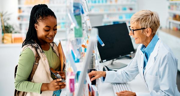 Frau zeigt Apothekerin ihr Smartphone.